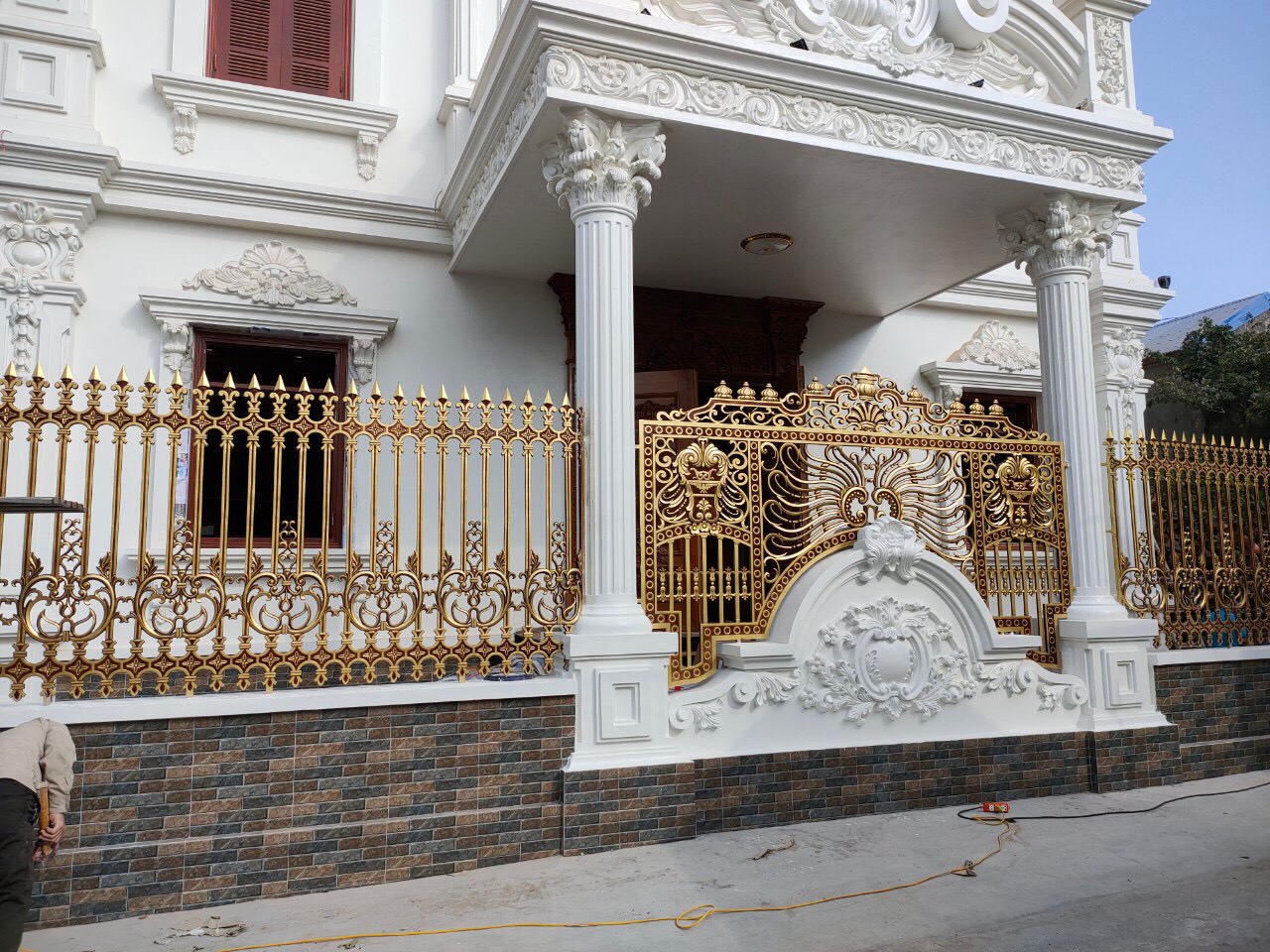 Mẫu hàng rào nhôm đúc sơn màu vàng đồng nổi bật trước ngôi nhà trắng